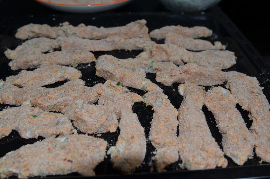 chicken in poni breadcrumbs on a baking tray, ready to bake