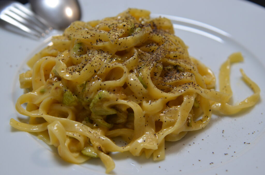 Creamy vegetarian carronara with courgettes on a plate, liberally sprinkled with black pepper
кремовая вегетарианская каронара с кабачками на тарелке, обильно посыпанная черным перцем